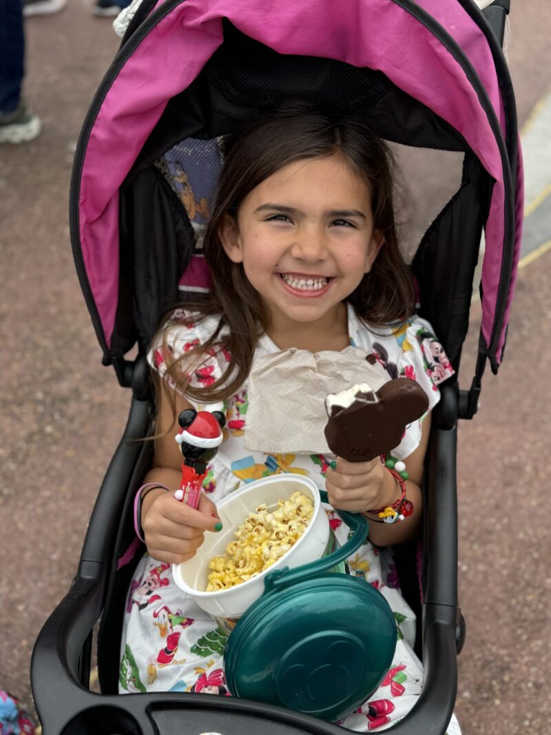Travel with Carie - Summer Tips - Girl in stroller with Mickey Bar